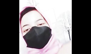hijab woman playing with dildo in room